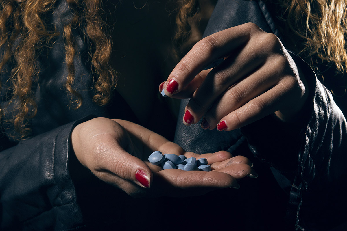close up of woman holding pills in hand for her Xanax addiction