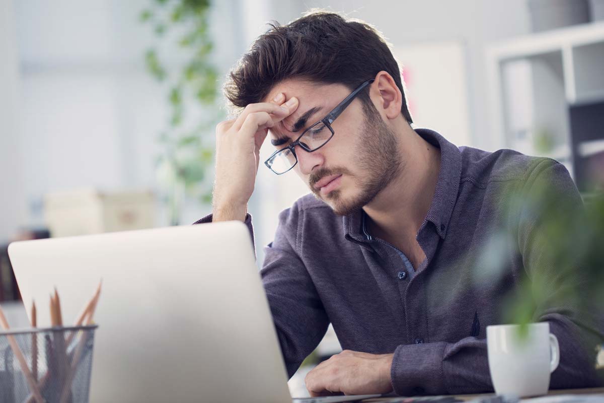 a man at his computer looking at the effects of ocd and alcoholism