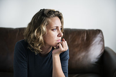 addictive personality traits woman on couch looking off
