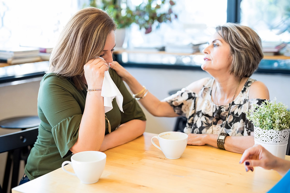 woman consoling crying daughter needing to learn how to find addiction treatment for a loved one