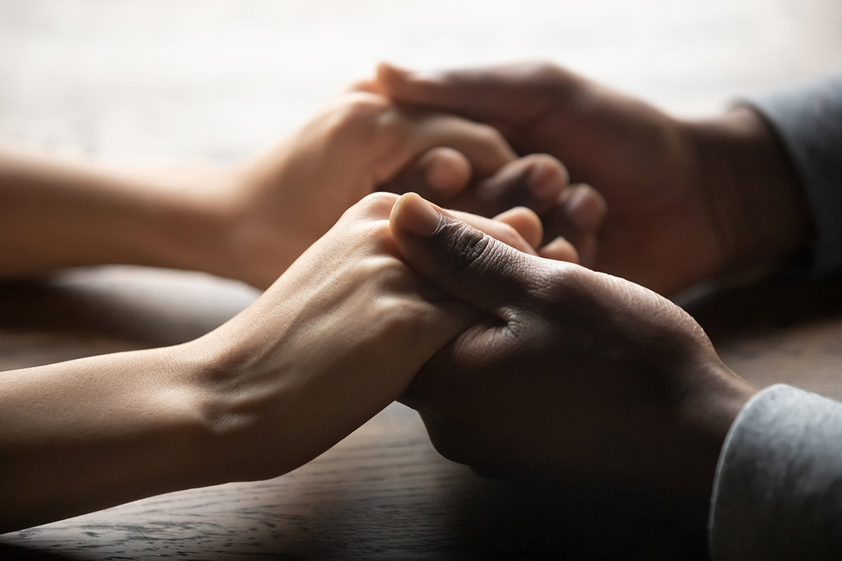 two people holding hands realizing the importance of trauma therapy during addiction treatment