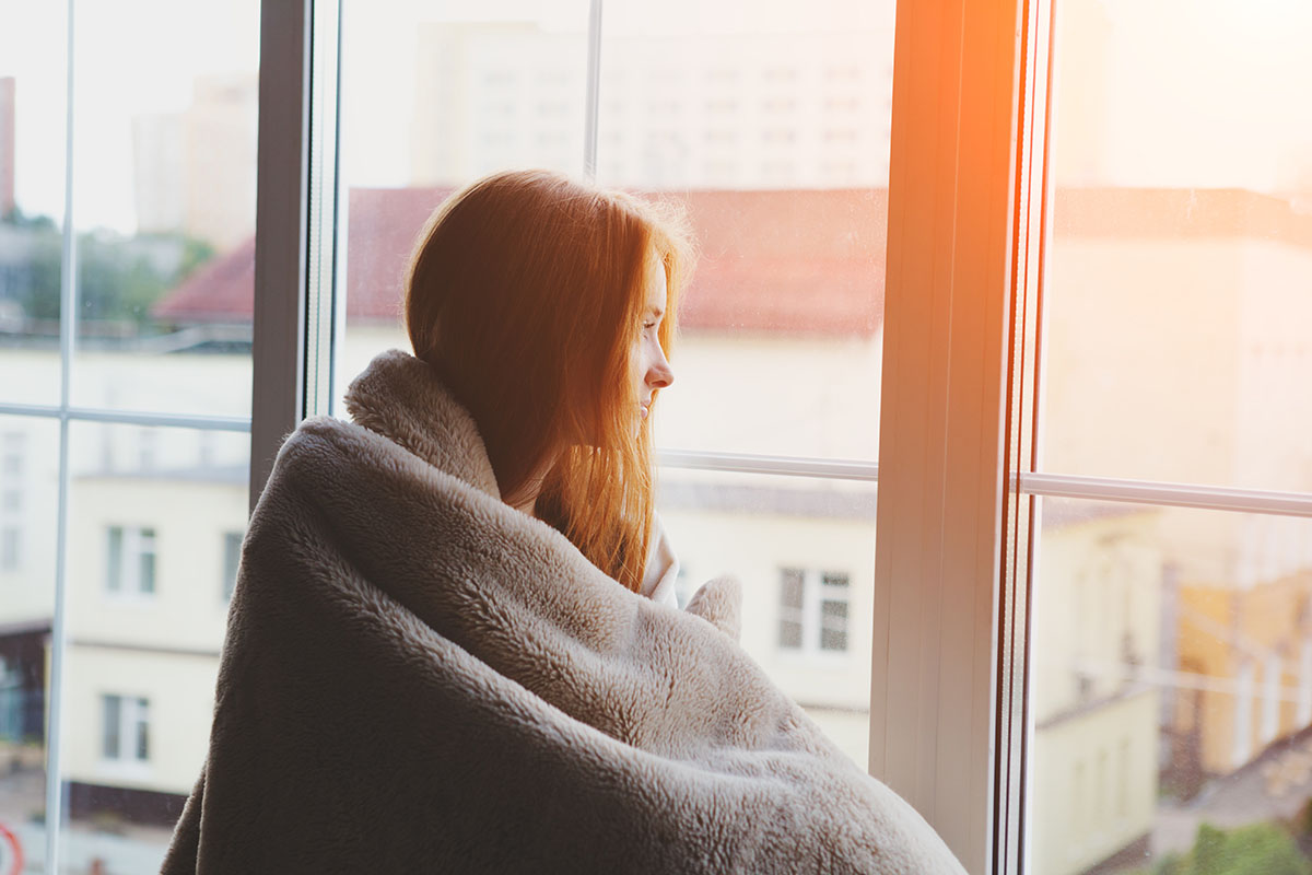 woman curled up practicing social distancing